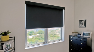 room darkening roller shade in black in a bedroom - office